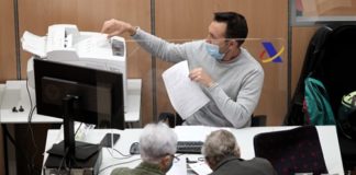 Un trabajador de la Agencia Tributaria atiende a dos personas.