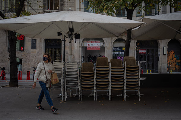 Una mujer pasea junto a una terraza cerrada en Barcelona. Foto: Europa Press.