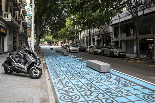 Una calle de Barcelona con bloques de hormigón a modo de bancos para los viandantes.