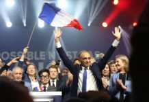 Éric Zemmour durante un mitin rodeado de personas y con una bandera de Francia.