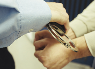 Policía esposando a una persona.