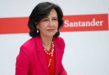 La presidenta del Banco Santander, Ana Botín, con chaqueta roja y delante del logotipo de la entidad.