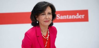 La presidenta del Banco Santander, Ana Botín, con chaqueta roja y delante del logotipo de la entidad.