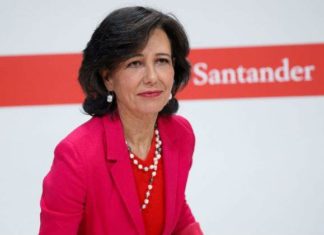La presidenta del Banco Santander, Ana Botín, con chaqueta roja y delante del logotipo de la entidad.