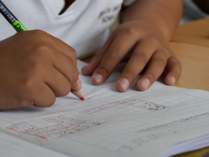 Niño rellenando fichas en el colegio.