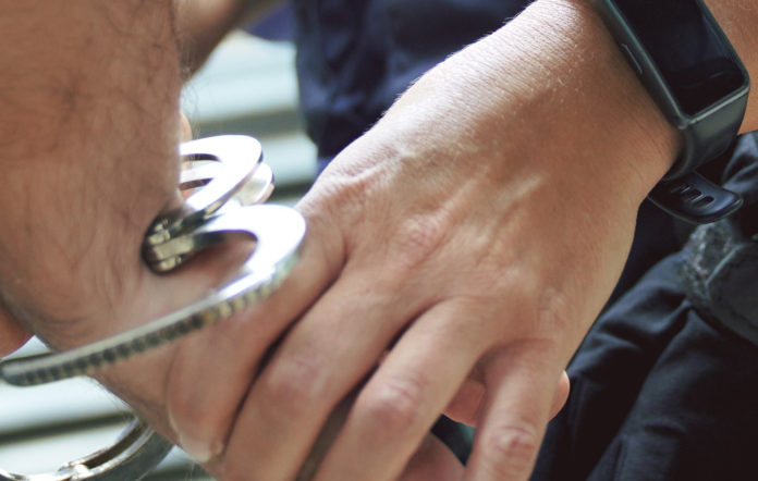 Un mosso esposando a un detenido