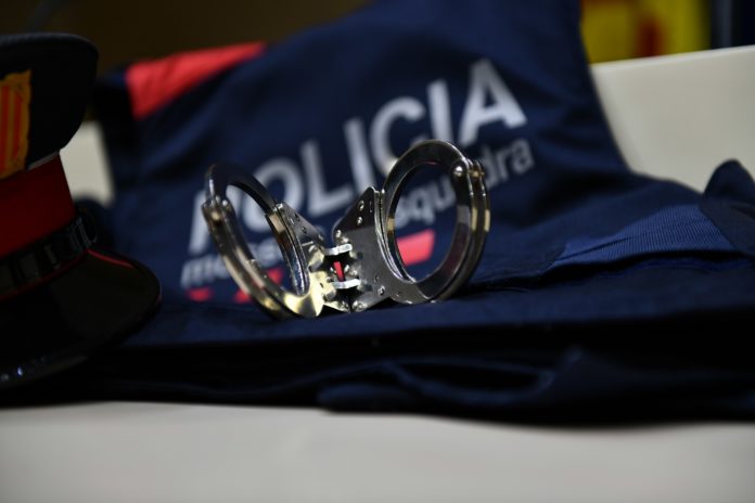 Vista de unas esposas sobre un uniforme de los Mossos.