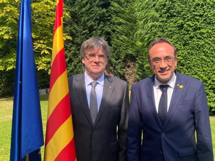 Carles Puigdemont y el presidente del Parlament, Josep Rull, en Waterloo posando junto a la bandera de Cataluña.