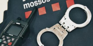 Vista de unas esposas, un walkie-talkie y un uniforme de los Mossos.