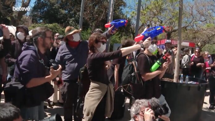 Captura de pantalla del momento en el que los manifestantes disparan con pistolas de agua al autobús turístico en la zona de Sagrada Familia, en Barcelona.