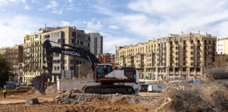 Una excavadora trabajando en un solar destinado a vivienda pública en el barrio de Glòries, en Barcelona.
