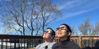 Un hombre y una mujer observan un eclipse de sol con unas gafas especiales.