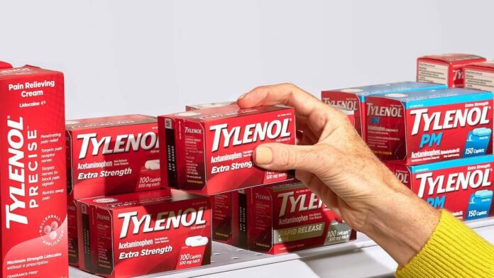 Cajas de Tylenol y una mano cogiendo una de las cajas.