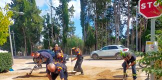Voluntarios de Protección Civil retirando barro y tierra de una calle durante las tareas de limpieza tras las lluvias en Cataluña.