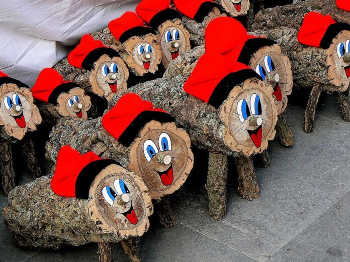 Muñecos del Caga Tió hechos de madera, con las caras pintadas y el tradicional gorro catalán.