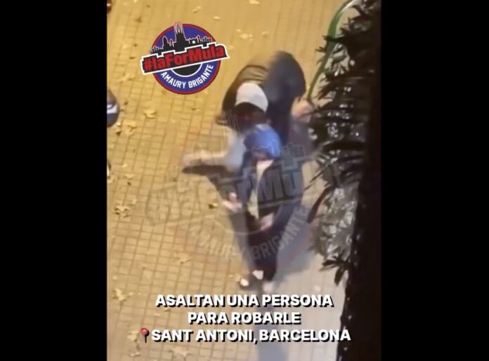 Captura de pantalla del vídeo en el que se observa cómo dos hombres agreden a otro en el suelo para robarle en el barrio de Sant Antoni, en Barcelona.