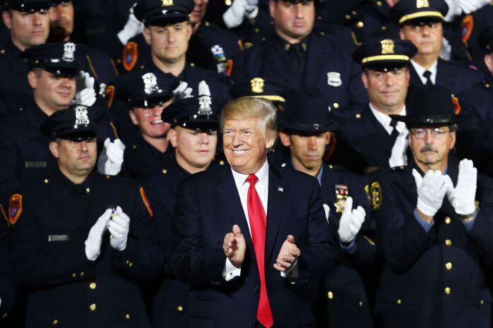 En el centro, el presidente Donald Trump, rodeado de policías.