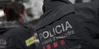 Dos Mossos d'Esquadra, un hombre y una mujer, de espaldas y con el uniforme.