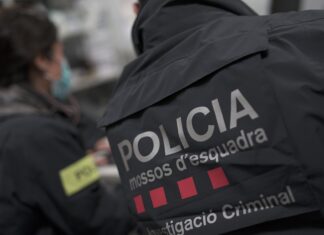 Dos Mossos d'Esquadra, un hombre y una mujer, de espaldas y con el uniforme.