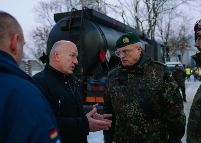 En el centro, el alcalde de Berlín, Kai Wegner, junto a un militar y delante de un camión de combustible.