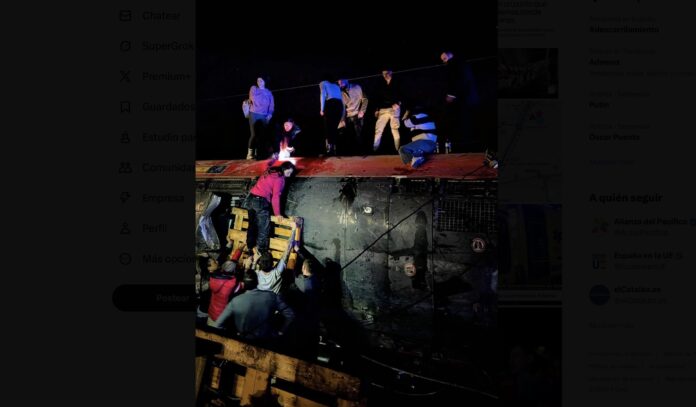 Pasajeros del tren de Iryo saliendo de uno de los vehículos volcados sobre la vía.