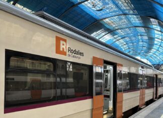 Tren de Rodalies parado en una estación y con las puertas abiertas.