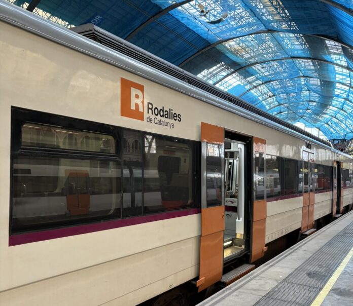 Tren de Rodalies parado en una estación y con las puertas abiertas.