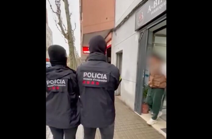 Mossos d'Esquadra custodian al detenido por financiar a Hamás a la salida de una peluquería en L'Hospitalet de Llobregat.