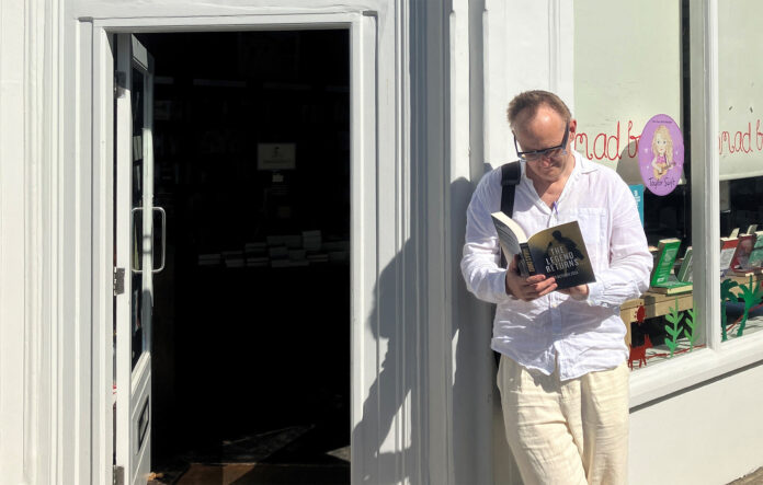 Nick Harkaway, autor de 'La decisión de Karla', posa junto a la puerta de una librería.