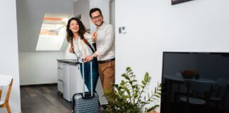 Una pareja entra en un alojamiento turístico (Envato).