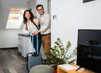 Una pareja entra en un alojamiento turístico (Envato).