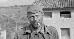 Retrato en blanco y negro del voluntario internacional Alvah Bessie con uniforme militar y un cigarrillo, durante la Guerra Civil española.