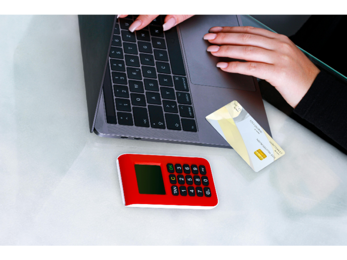 Persona utilizando un ordenador y una tarjeta para contratar un crédito rápido online en Cataluña.