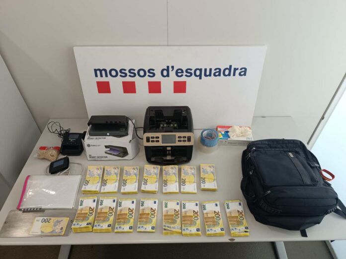 Billetes falsos de 200 euros y máquinas contadoras intervenidos por los Mossos d'Esquadra en una estafa Rip Deal en Barcelona.