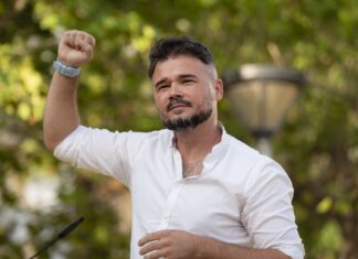 Gabriel Rufián, portavoz de ERC, levantando el puño izquierdo durante un acto político.