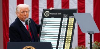 Donald Trump muestra una tabla informativa sobre su política de aranceles comerciales en una comparecencia.