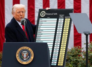 Donald Trump muestra una tabla informativa sobre su política de aranceles comerciales en una comparecencia.