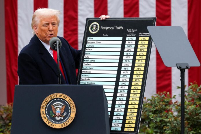 Donald Trump muestra una tabla informativa sobre su política de aranceles comerciales en una comparecencia.