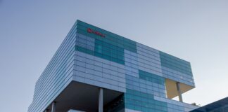 Fachada exterior del edificio de la sede de Veolia en Barcelona, una estructura moderna de cristal y metal bajo un cielo despejado.