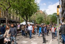 Persones caminant per un carrer de Barcelona en una escena quotidiana de vida urbana