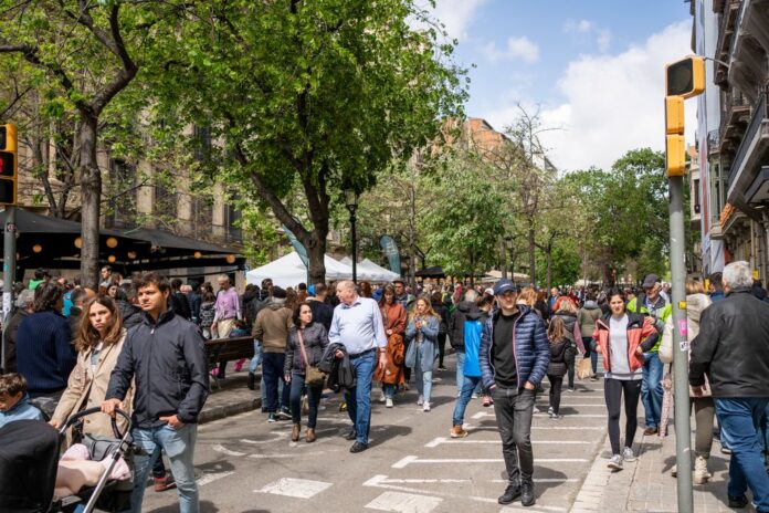 Persones caminant per un carrer de Barcelona en una escena quotidiana de vida urbana