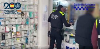 Agentes de la Policía Nacional y Guardia Urbana en una tienda de telefonía en Barcelona durante la operación contra la estafa del router.