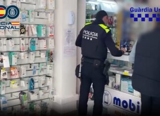 Agentes de la Policía Nacional y Guardia Urbana en una tienda de telefonía en Barcelona durante la operación contra la estafa del router.