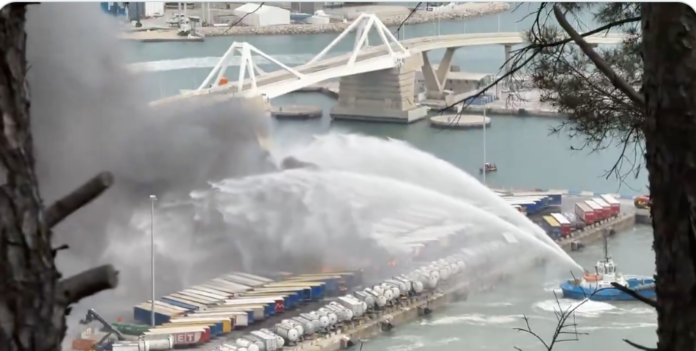 Momento en el que intentan apagar el fuego, originado en el Moll de Ponent del Puerto de Barcelona.