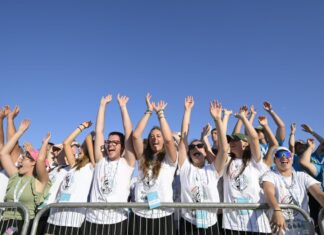 Un grup de joves a Tor Vergata, amb les mans aixecades en senyal d'alegria, darrere d'una tanca de seguretat, durant el Jubileu dels Joves.