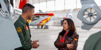 La ministra de Defensa, Margarita Robles, con una chaqueta de vuelo, conversando con un oficial en la Escuela Militar de Helicópteros en Armilla.