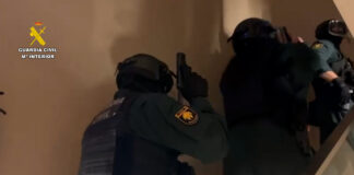 Agentes de la Guardia Civil con equipo táctico realizando una entrada y registro en una vivienda de Barcelona durante la operación Varkov contra las estafas amorosas.