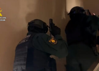 Agentes de la Guardia Civil con equipo táctico realizando una entrada y registro en una vivienda de Barcelona durante la operación Varkov contra las estafas amorosas.