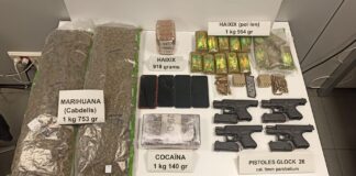 Arsenal incautado por los Mossos en La Mina con pistolas Glock, cocaína, hachís y marihuana sobre una mesa de evidencias.