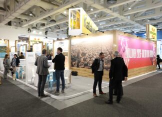 Cataluña refuerza su posición en la ITB de Berlín ante un mercado alemán que aumenta su gasto un 4,8% Vista general del stand de Cataluña en la Feria Internacional de Turisme de Berlín (ITB), con una gran fotografía aérea de Barcelona y profesionales del sector conversando.